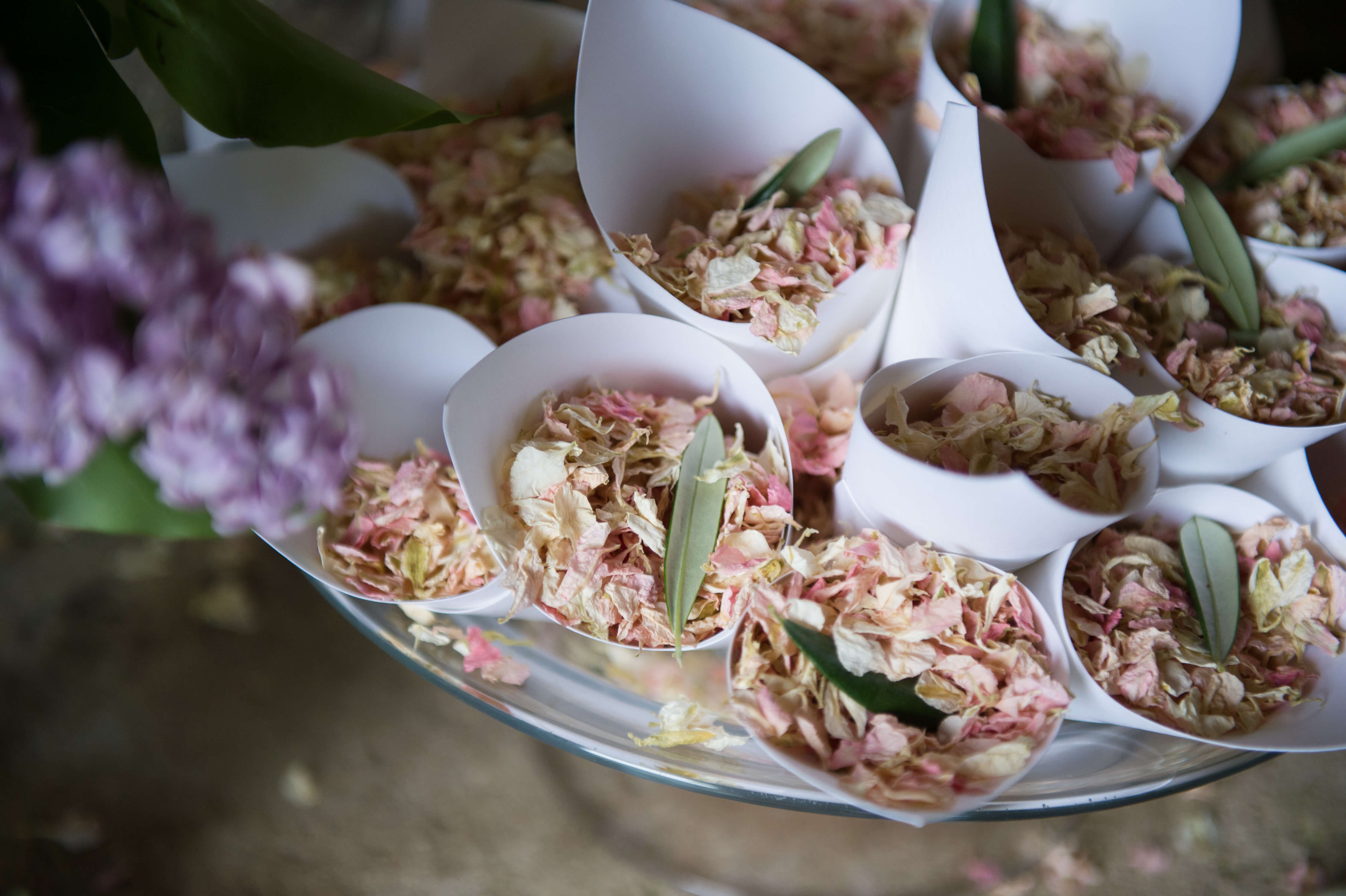 pink and cream flower petal confetti in cones outside the church door